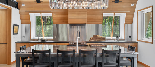 Kitchen with a crystal chandelier, wood ceiling and long island seating
