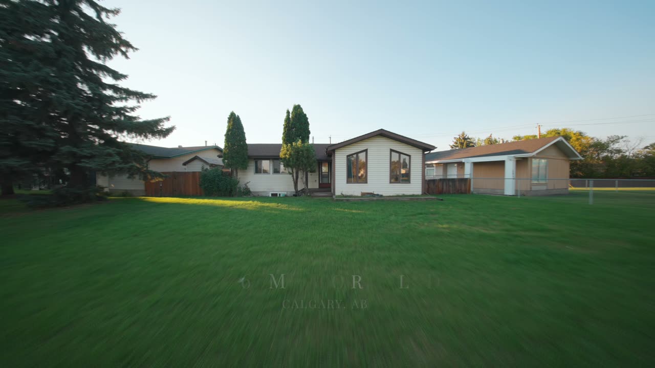 Listing film still: bungalow and backyard lawn in Calgary at golden hour