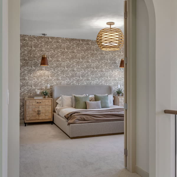 Arched doorway into a primary bedroom with a patterned feature wall