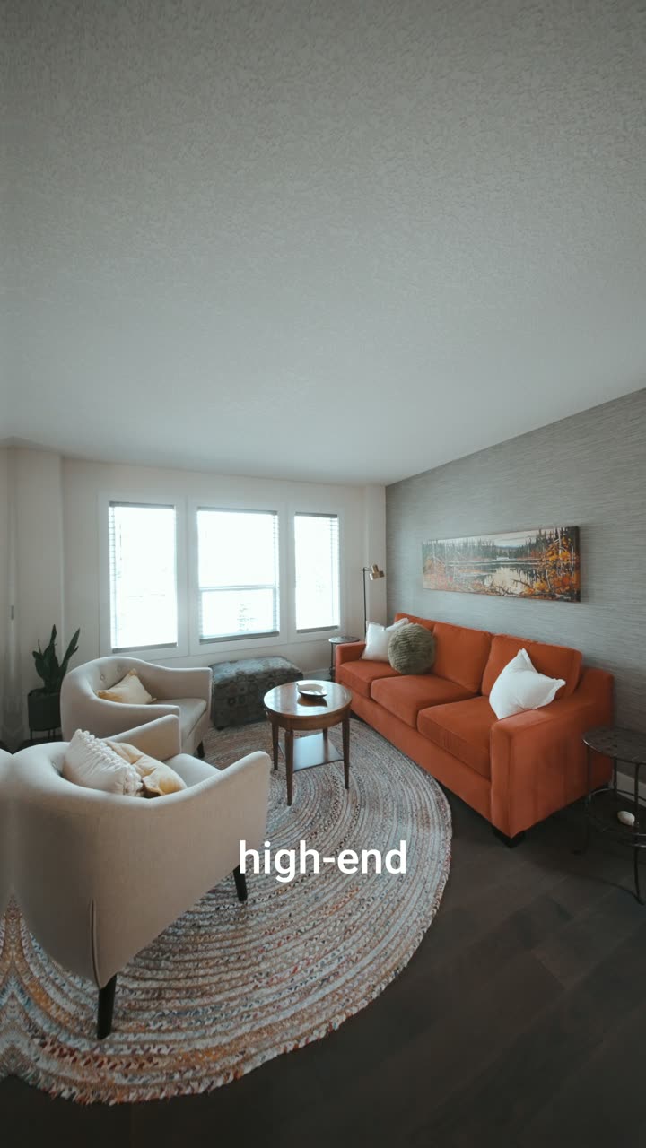 Vertical reel still: living room with an orange sofa and round rug